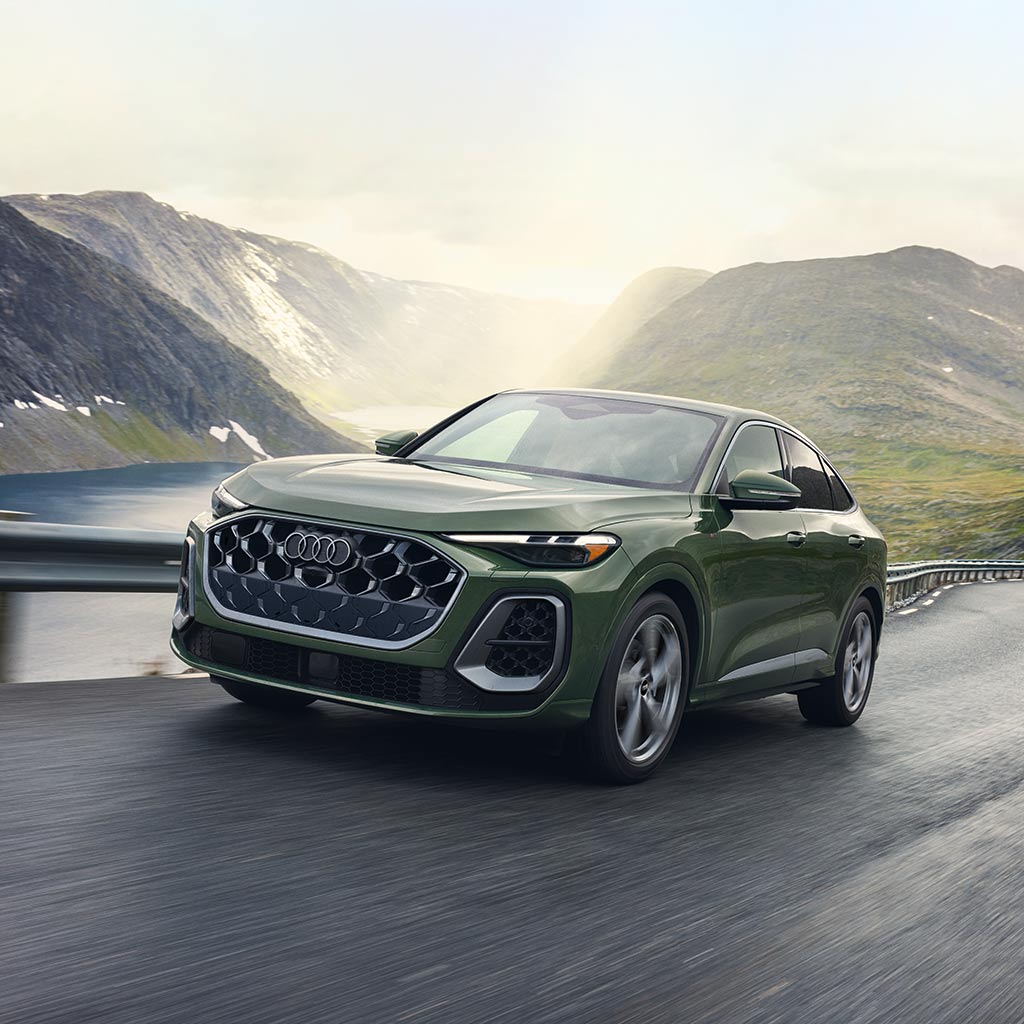 Three-quarter front view of an Audi Q5 Sportback driving along a mountain road.