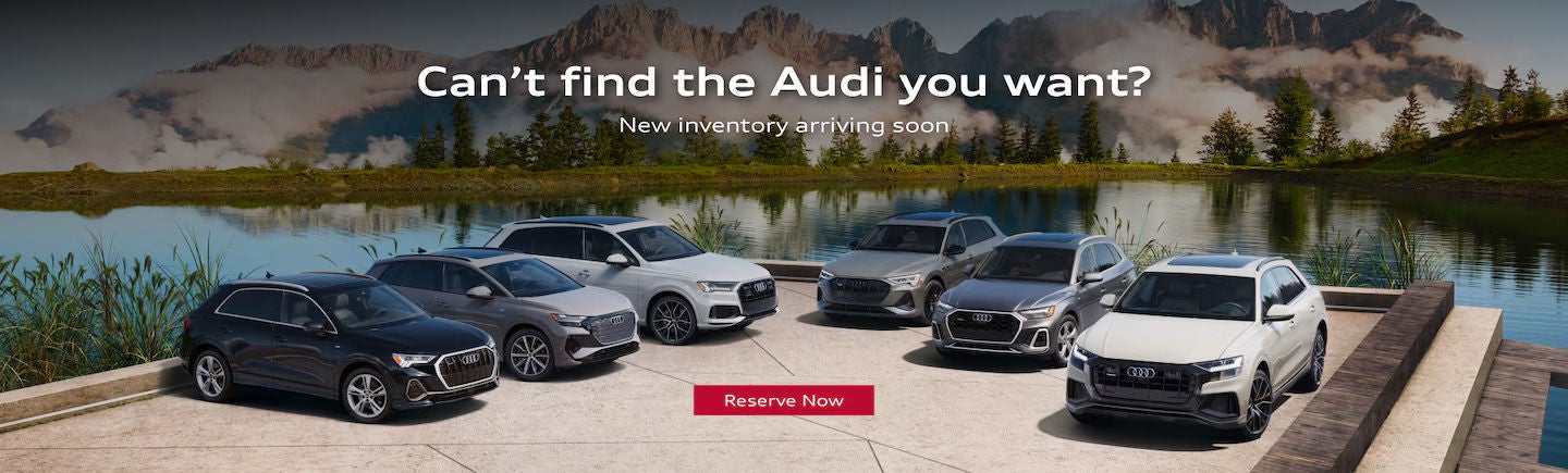 Audi SUV lineup parked on gravel road with hills in the background