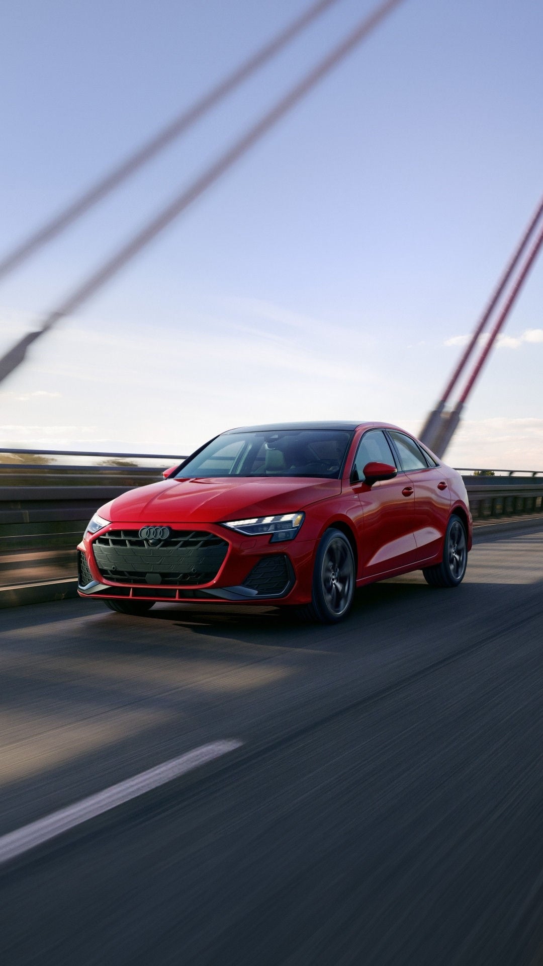 Front 3/4 profile of Audi A3 driving on the road.
