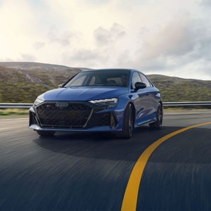The RS 3 sedan driving on a curve on the highway