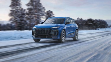 Three-quarter front view of the Audi Q6 e-tron driving.