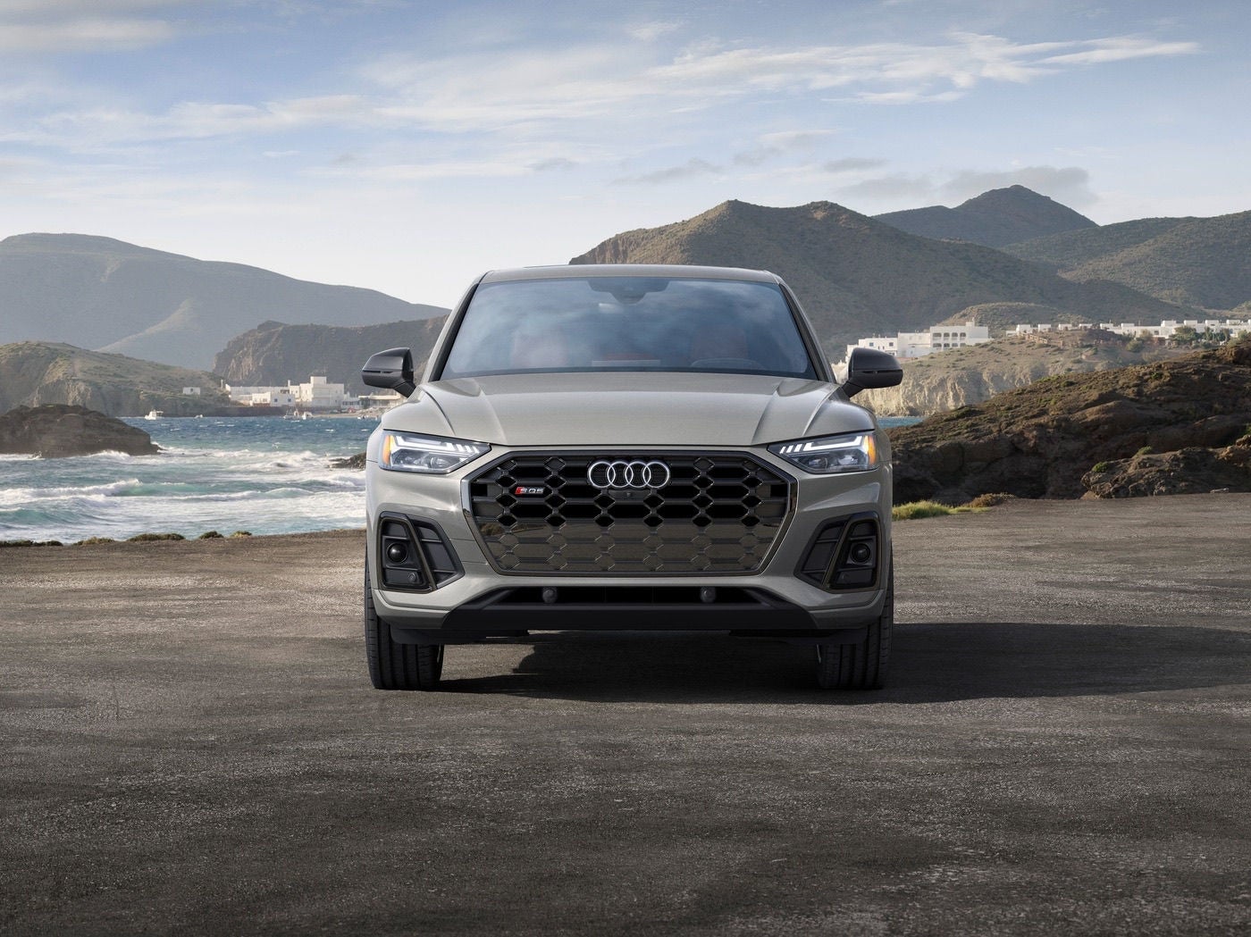 Gray Audi SQ5 parked near a coastal landscape.