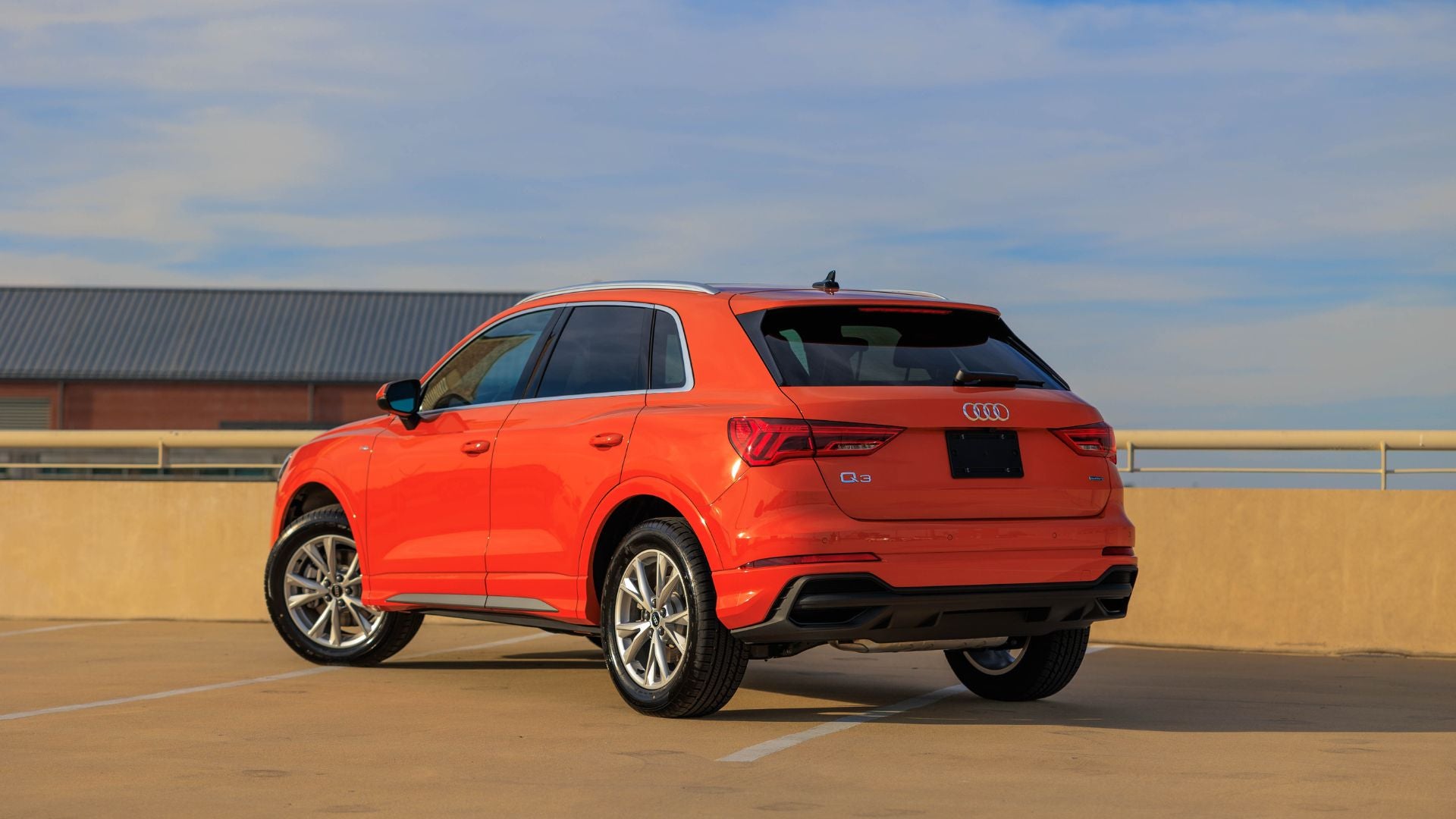 Back of the Audi Q3 parked. The SUV is orange