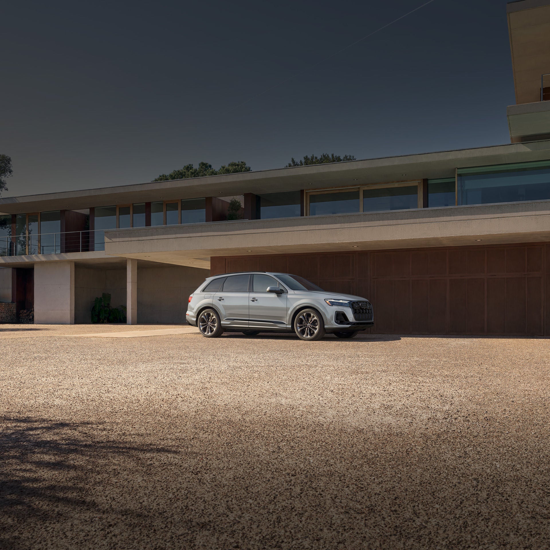 Side profile of a black Audi Q7 parked on a home driveway.