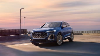 Three-quarter front view of the Audi SQ5 accelerating around a bend.