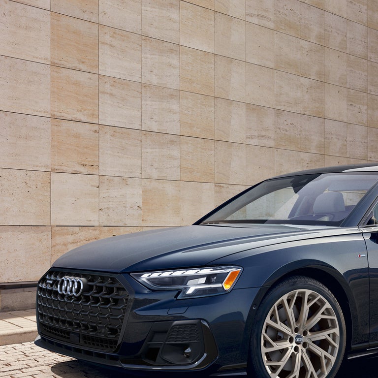 A close up, three-quarter front view of the Audi A8 parked.