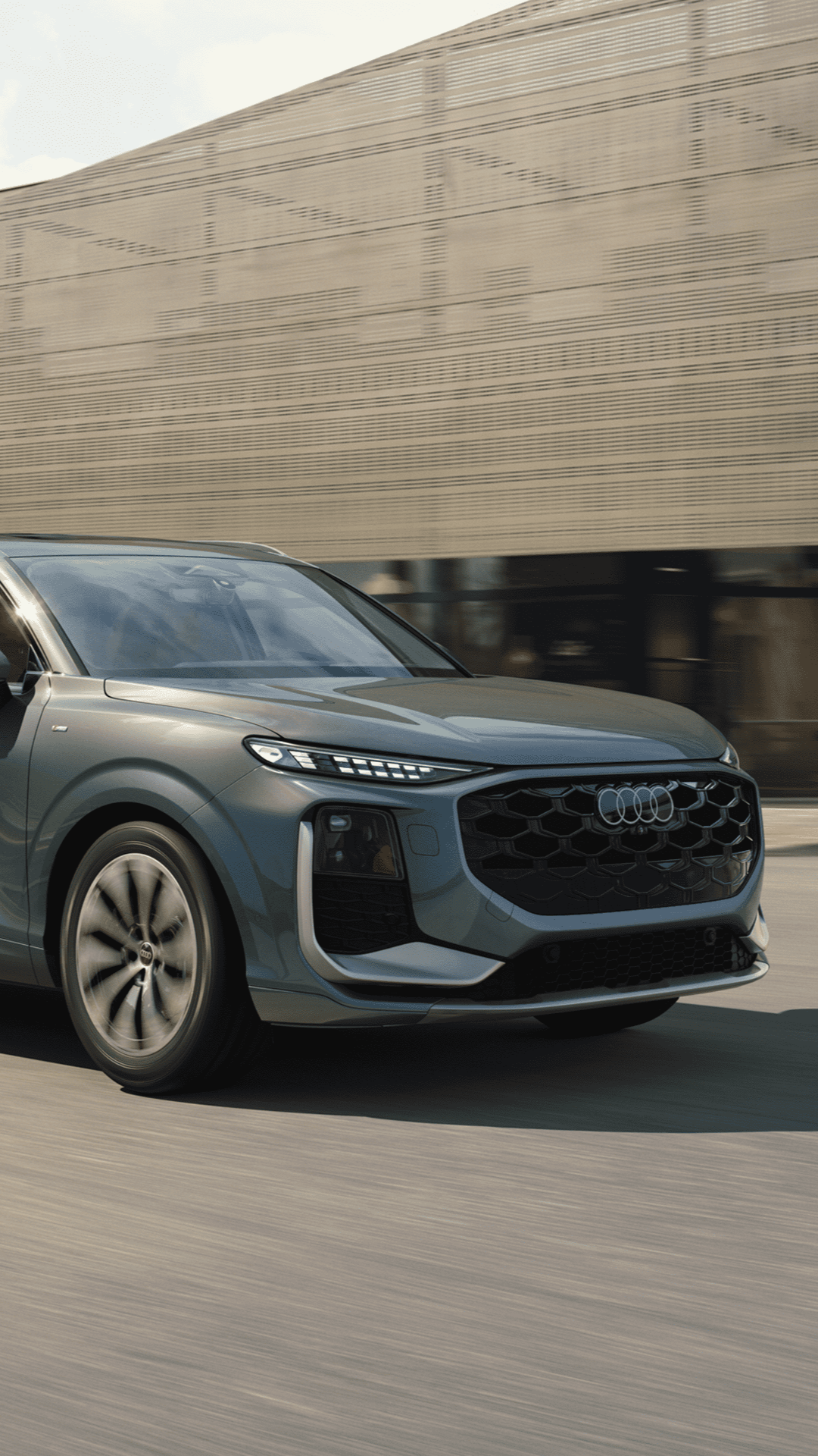 Left side profile view of an Audi Q3 accelerating.