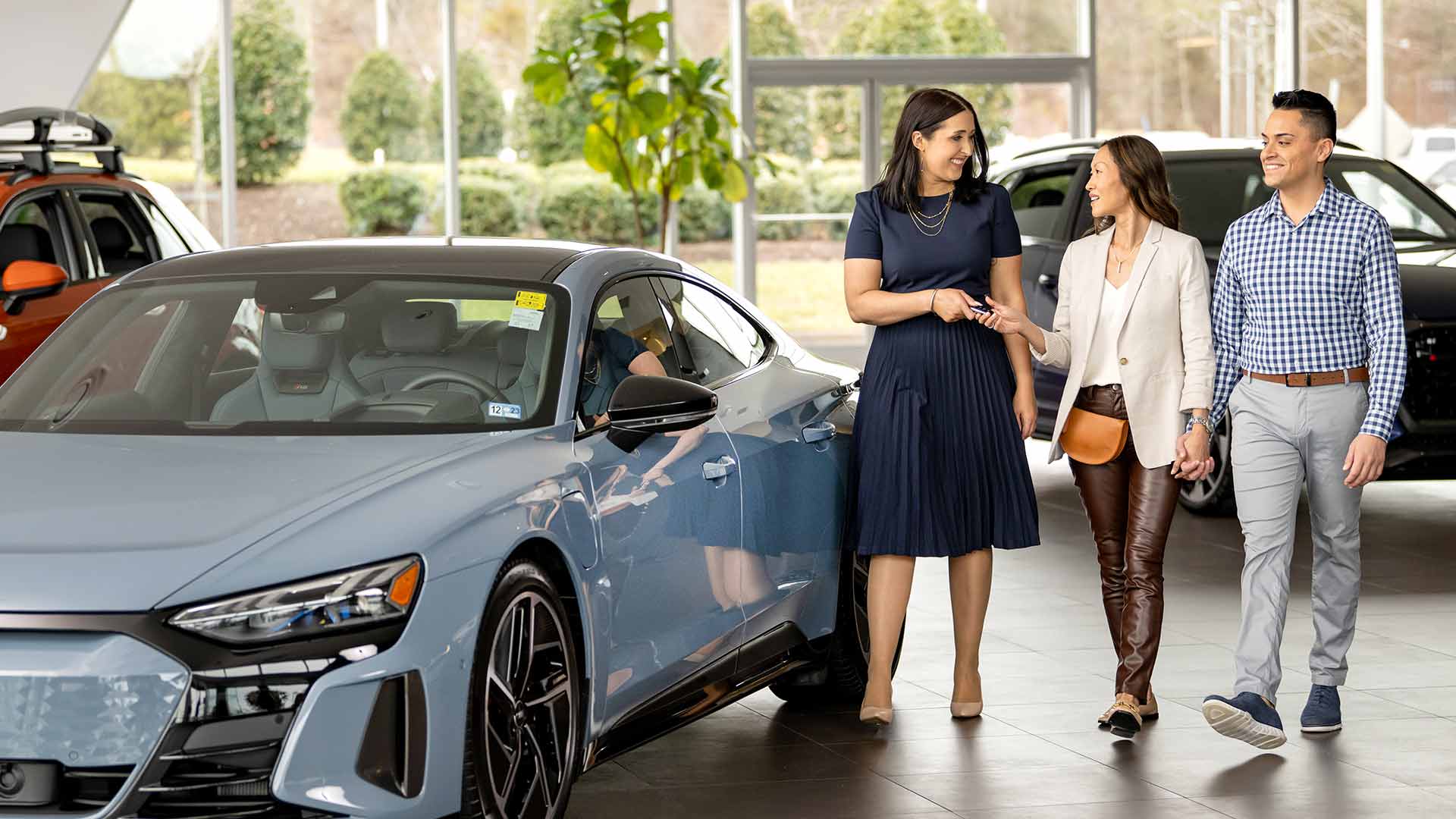 Sales person walking customers through Audi showroom