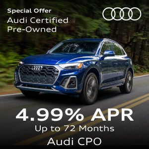 A blue Q5 driving in the forest.