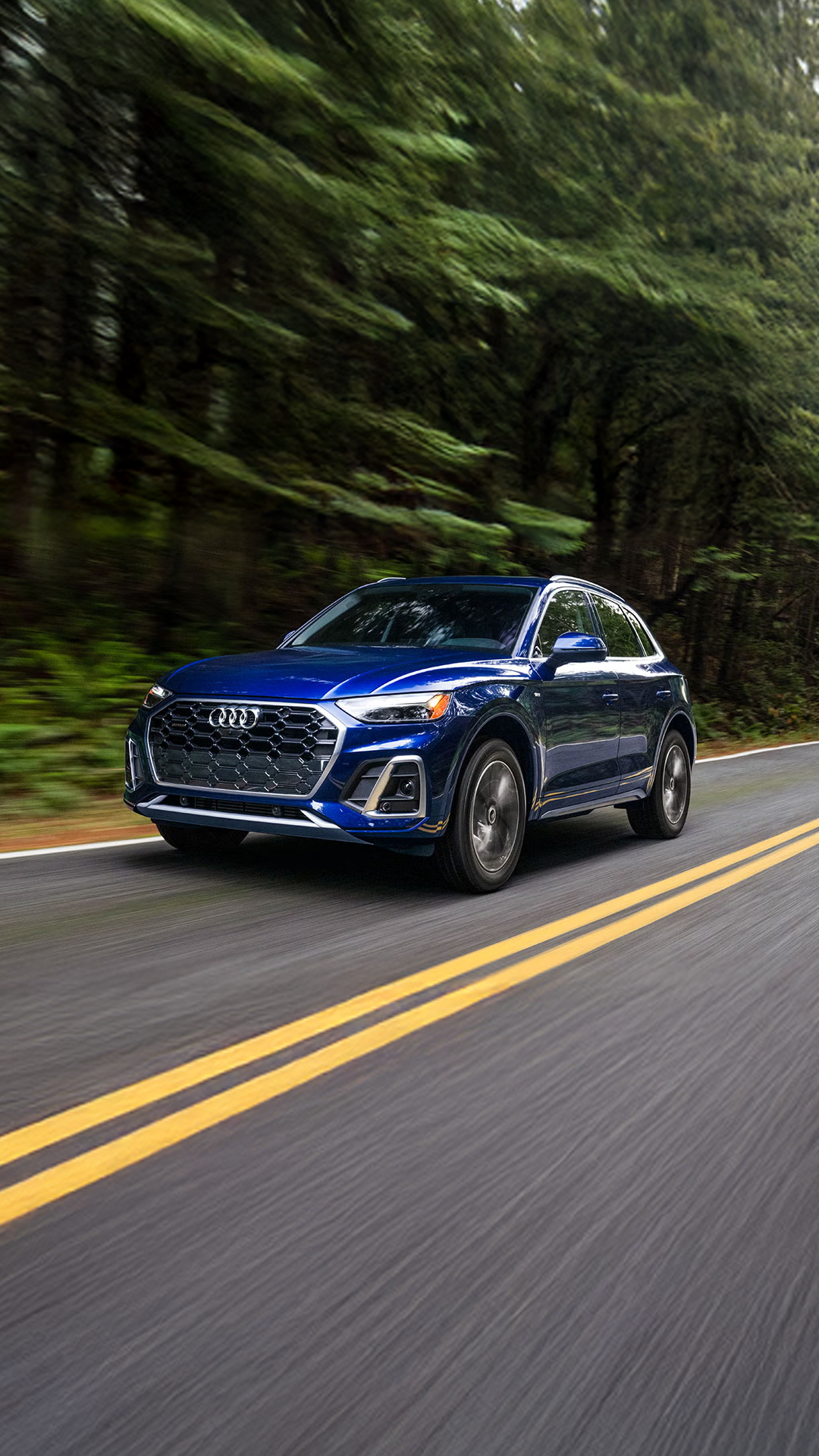 Photo of an Audi e-tron SUV parked near a wall.
