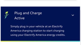 A red Audi RS e-tron GT plugged into a charging station at sunset.