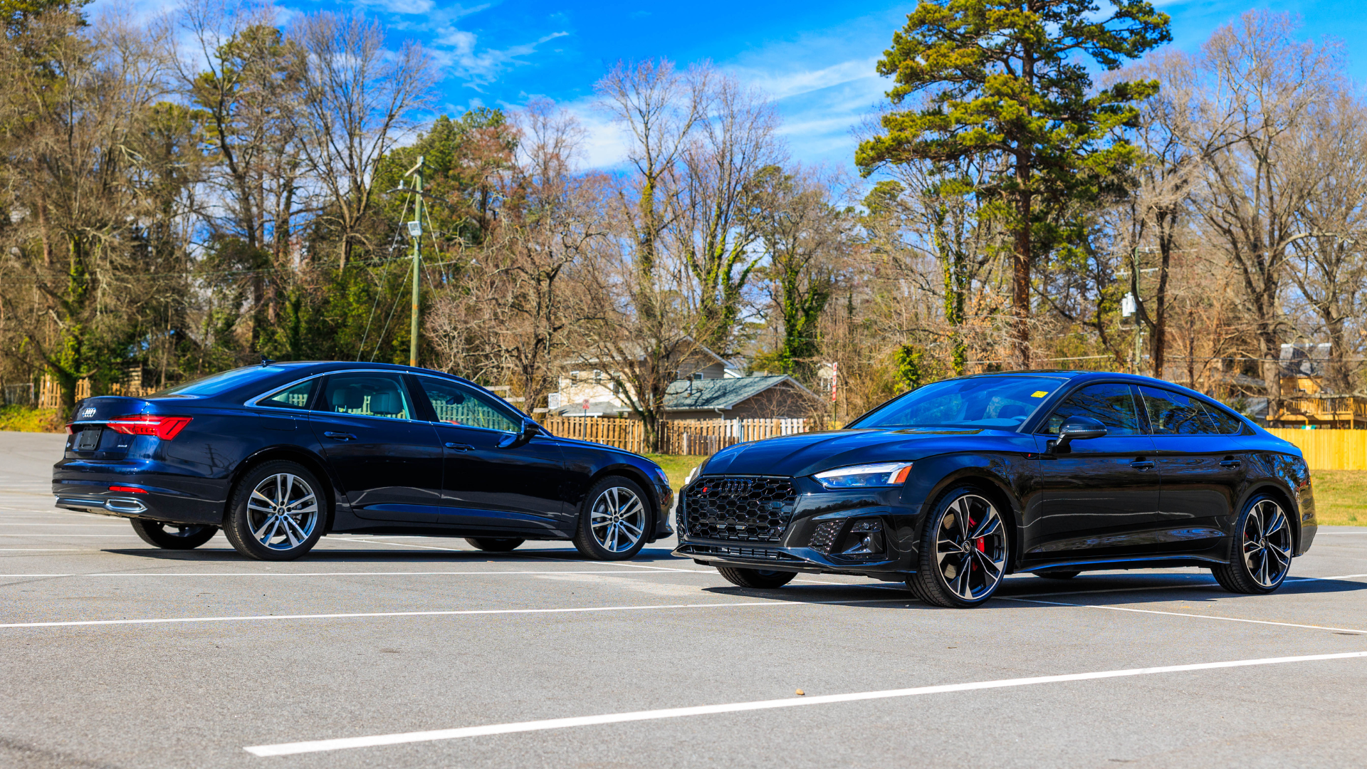 Two Audi sedans parked side by side outside.