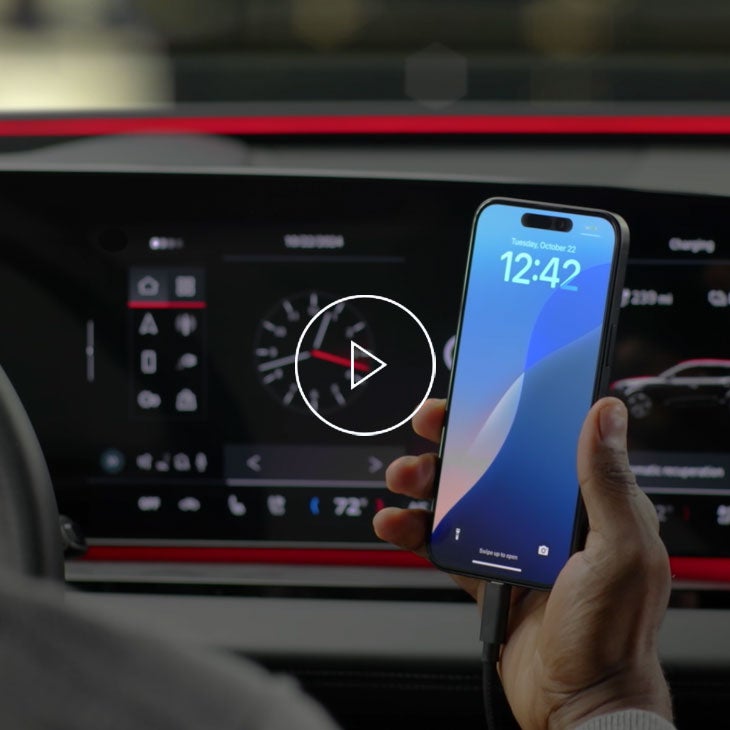 Close up on a person holding an iPhone in the Audi Q6 e-tron.