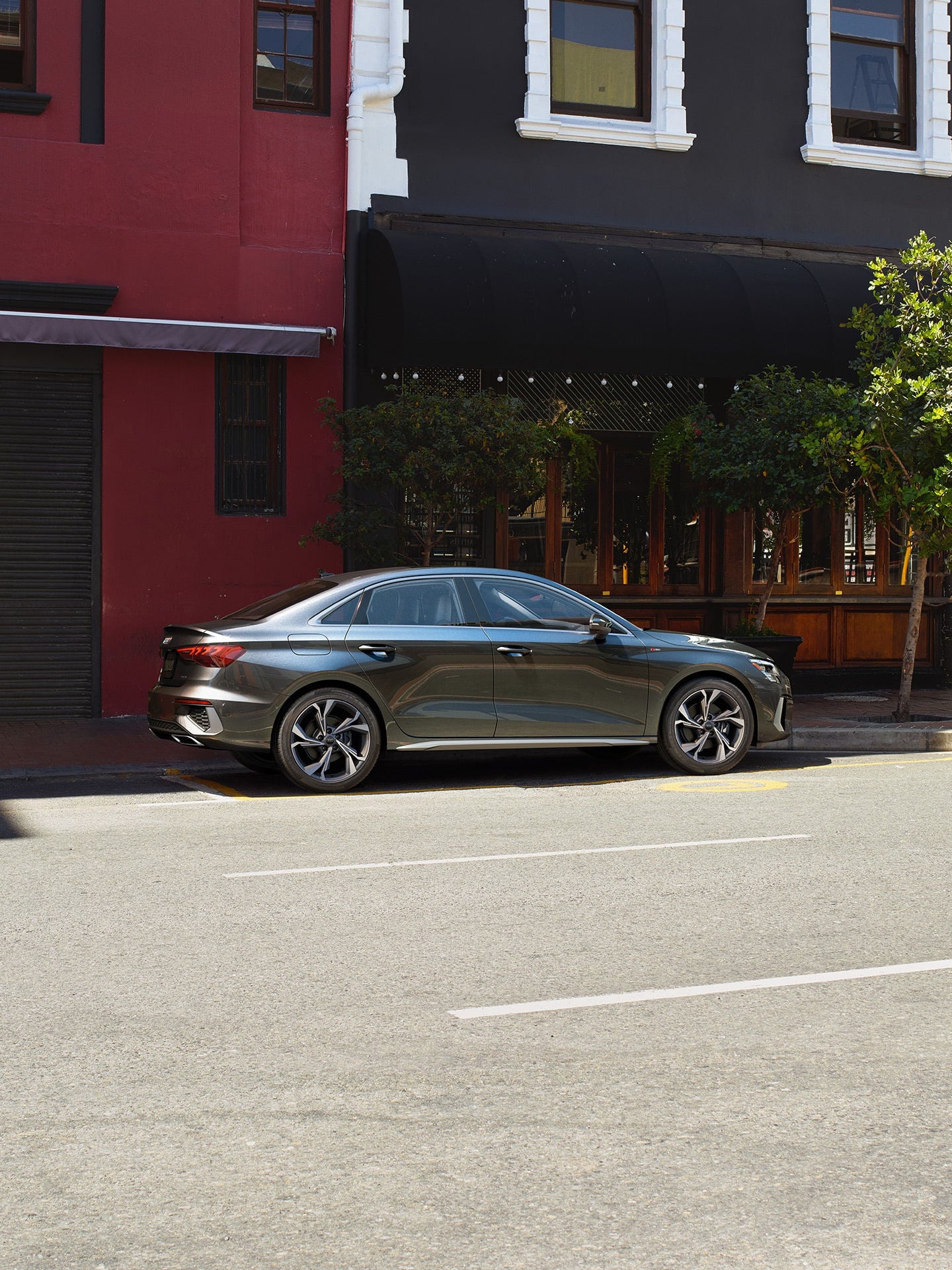 Vue latérale d'une Audi A3 grise garée dans une rue de la ville.