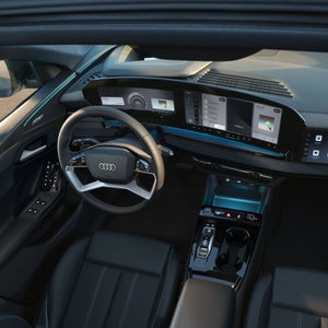 Interior view of the Audi Q6 Sportback e-tron through the sunroof, showing the interior lighting technology.