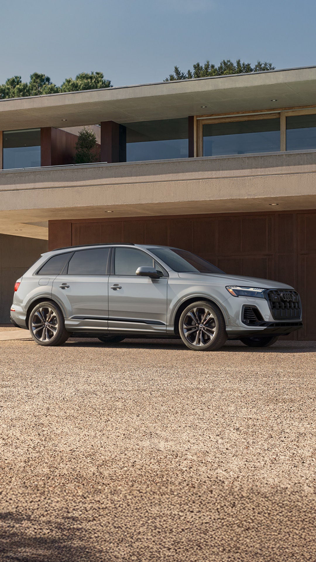 Side profile shot of the 2025 Audi Q7 parked in front of building.