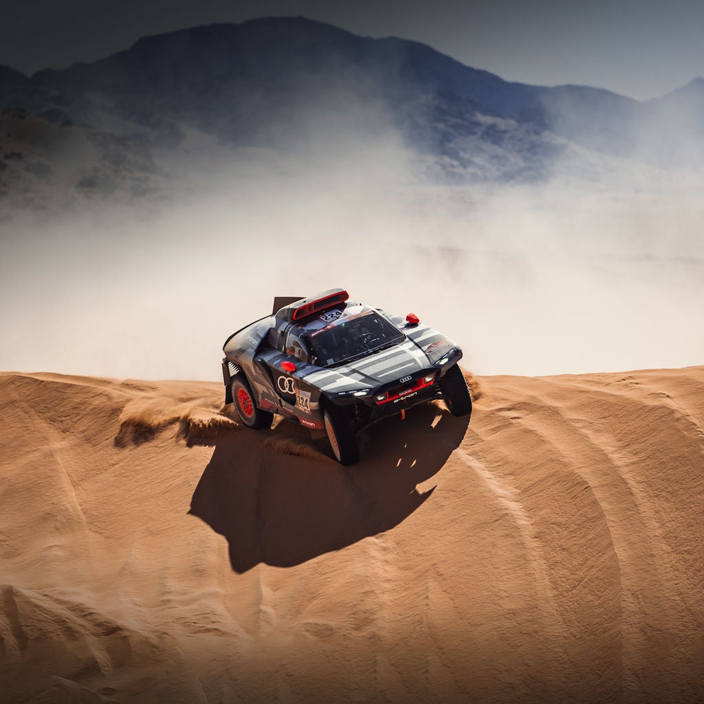 An Audi RS Q e-tron tackles a sand dune in the 2022 Dakar Rally.