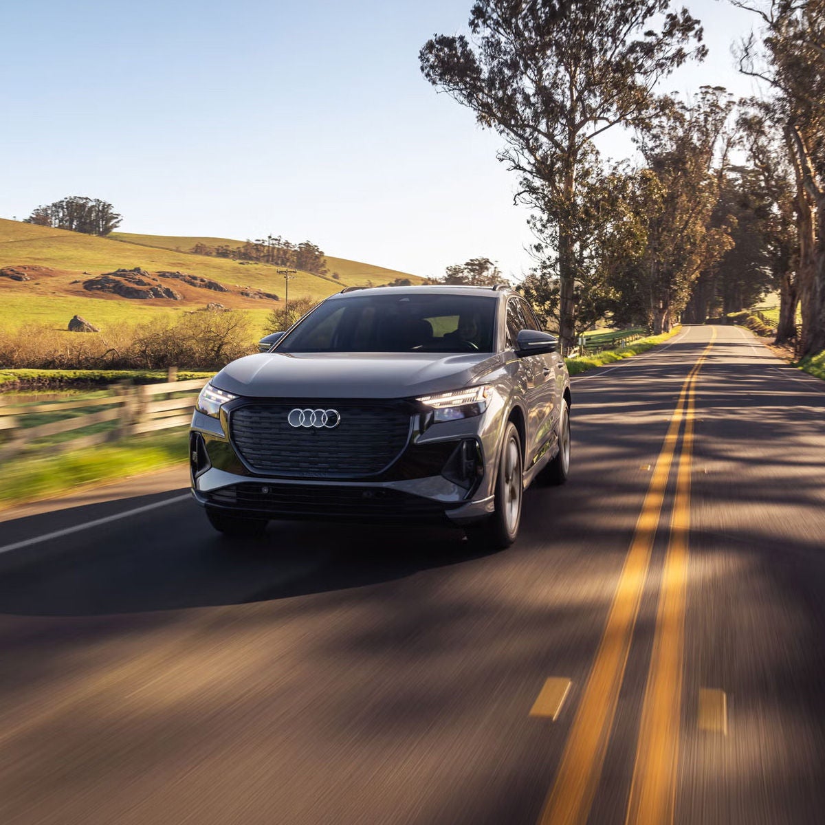 Front view of the Audi Q4 e-tron accelerating on a countryside road.