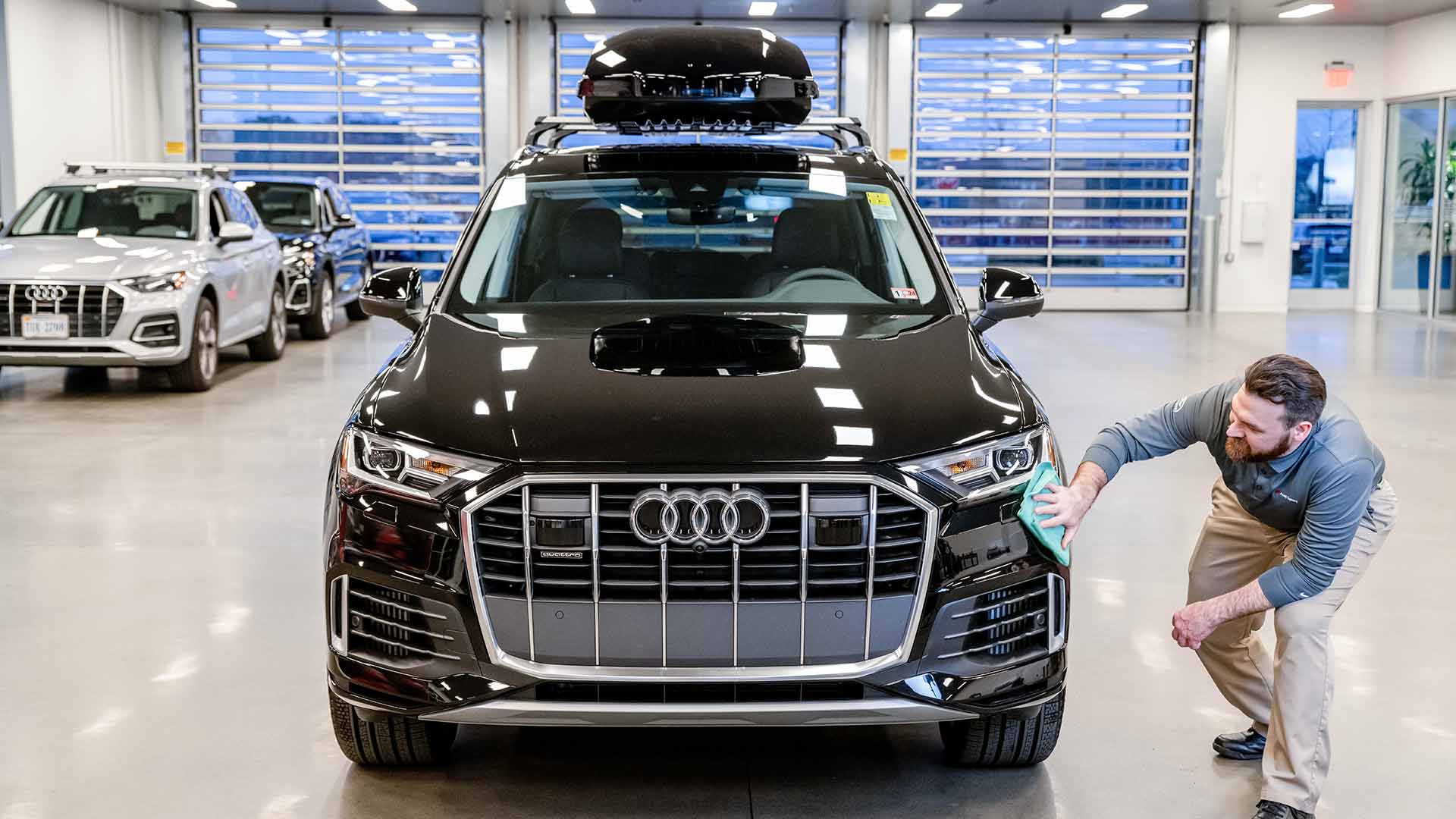 Audi employee inspecting vehicle.