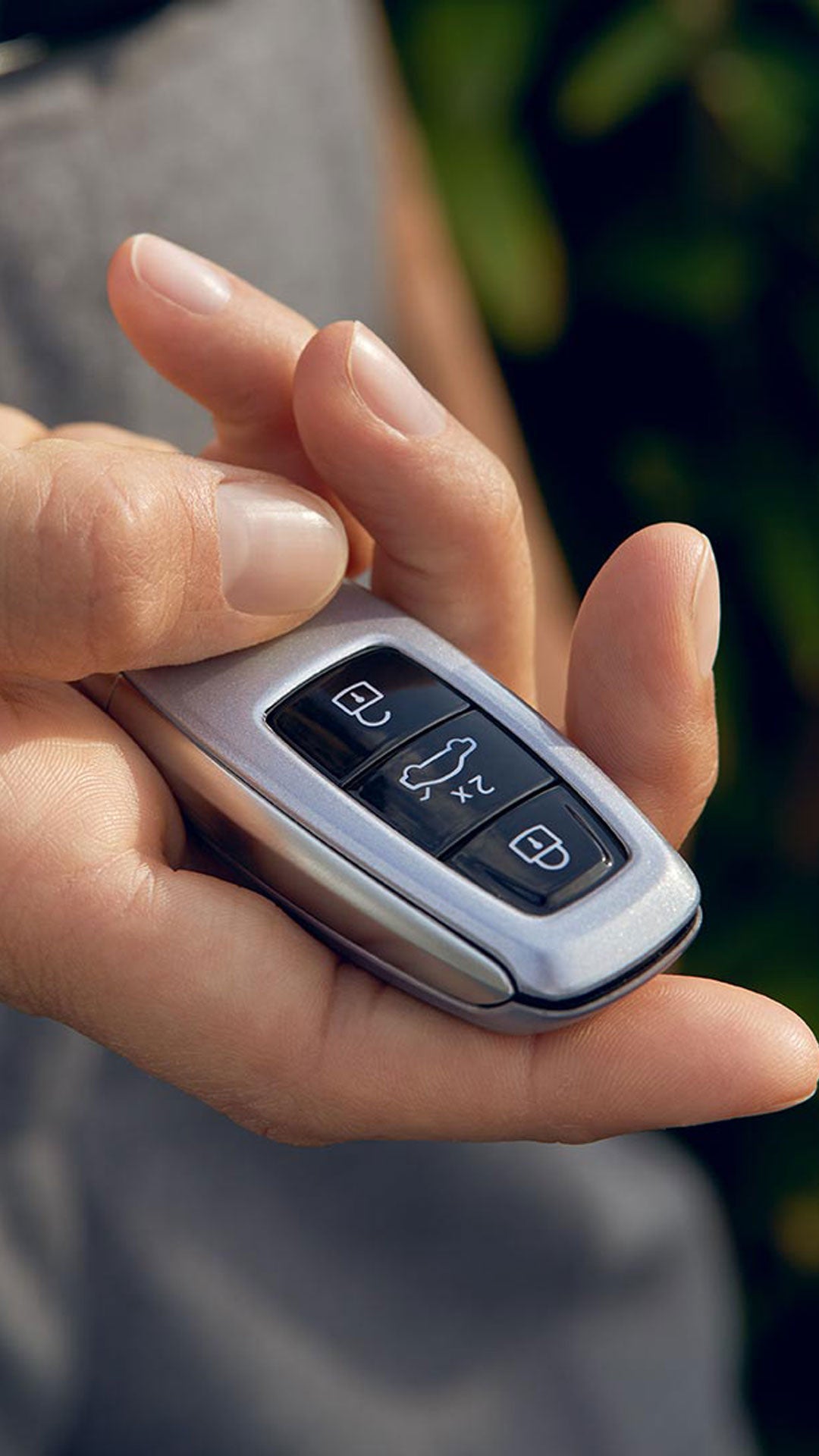 A close-up photo of someone's hand holding an Audi key fob.