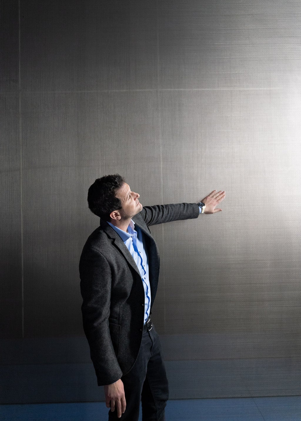 Thomas Redenbach, Head of Development Aerodynamics & Aeroacoustics at Audi, runs his hand along the side of the Audi aeroacoustic wind tunnel.