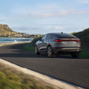 Profil arrière de l'Audi Q6 Sportback e-tron aux trois quarts en déplacement.