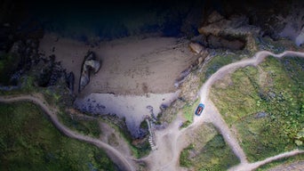 Aerial view of an Audi vehicle driving in a mountainous region.