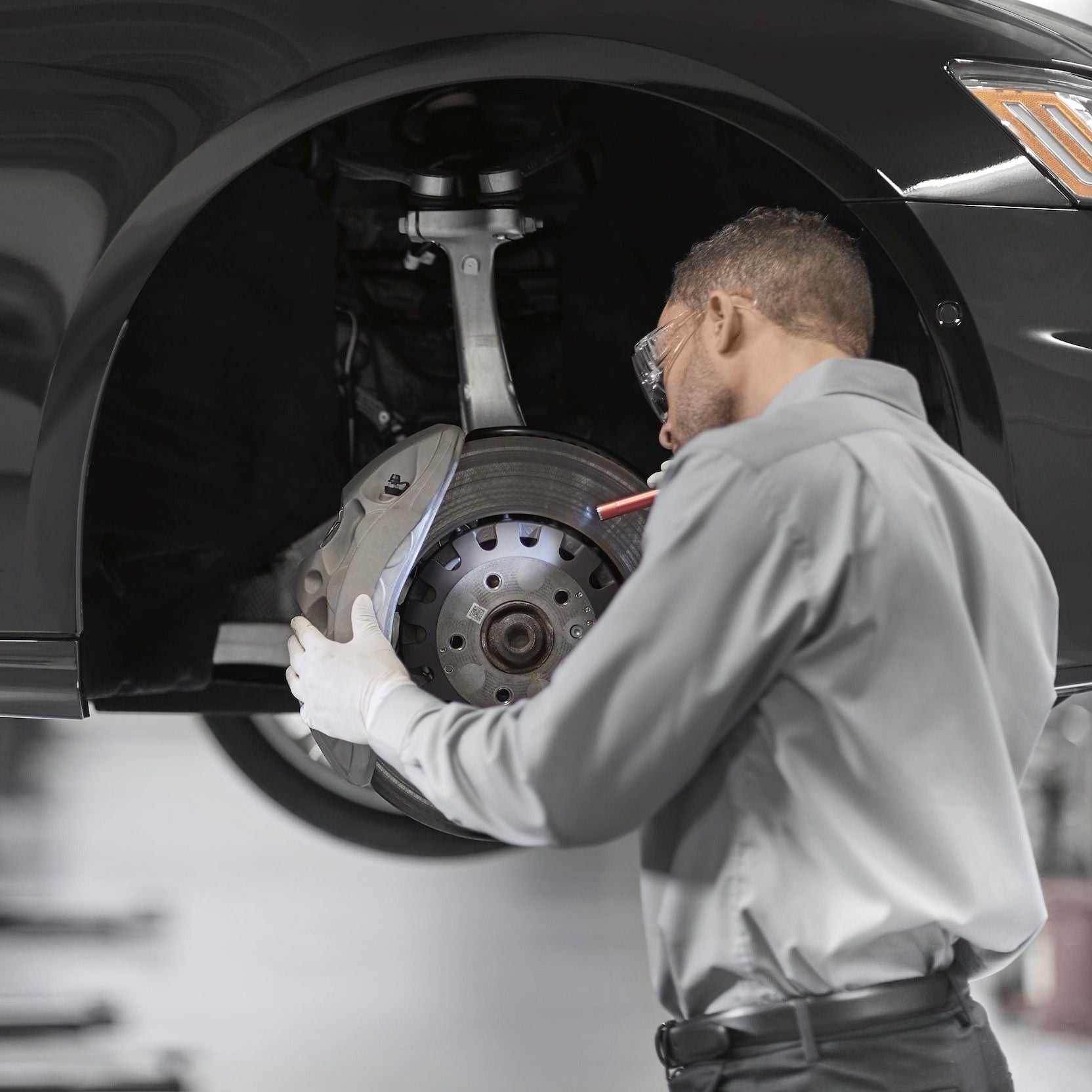 Audi service technician servicing a vehicle.