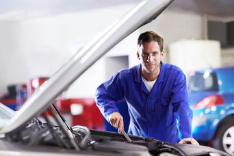 Service technician servicing vehicle.
