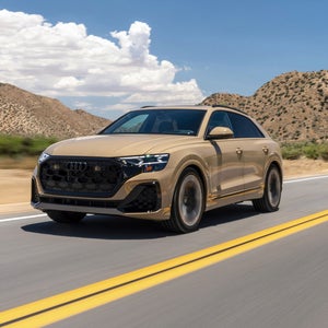 Side view of an Audi Q8 driving.