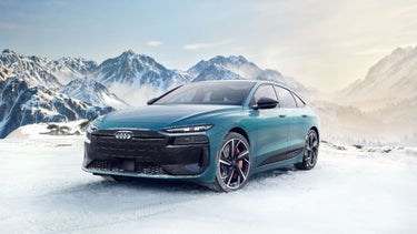 Three-quarter front view of the Audi S6 e-tron parked in front of a wintery mountainous landscape.