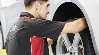 Service technician attaching tire.