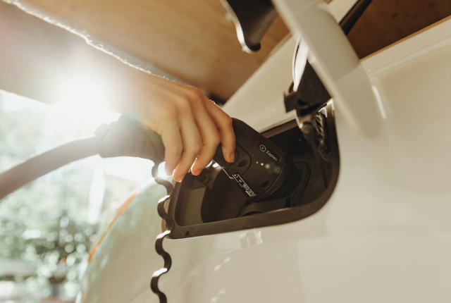 Hand plugging charging cable into an Audi electric vehicle