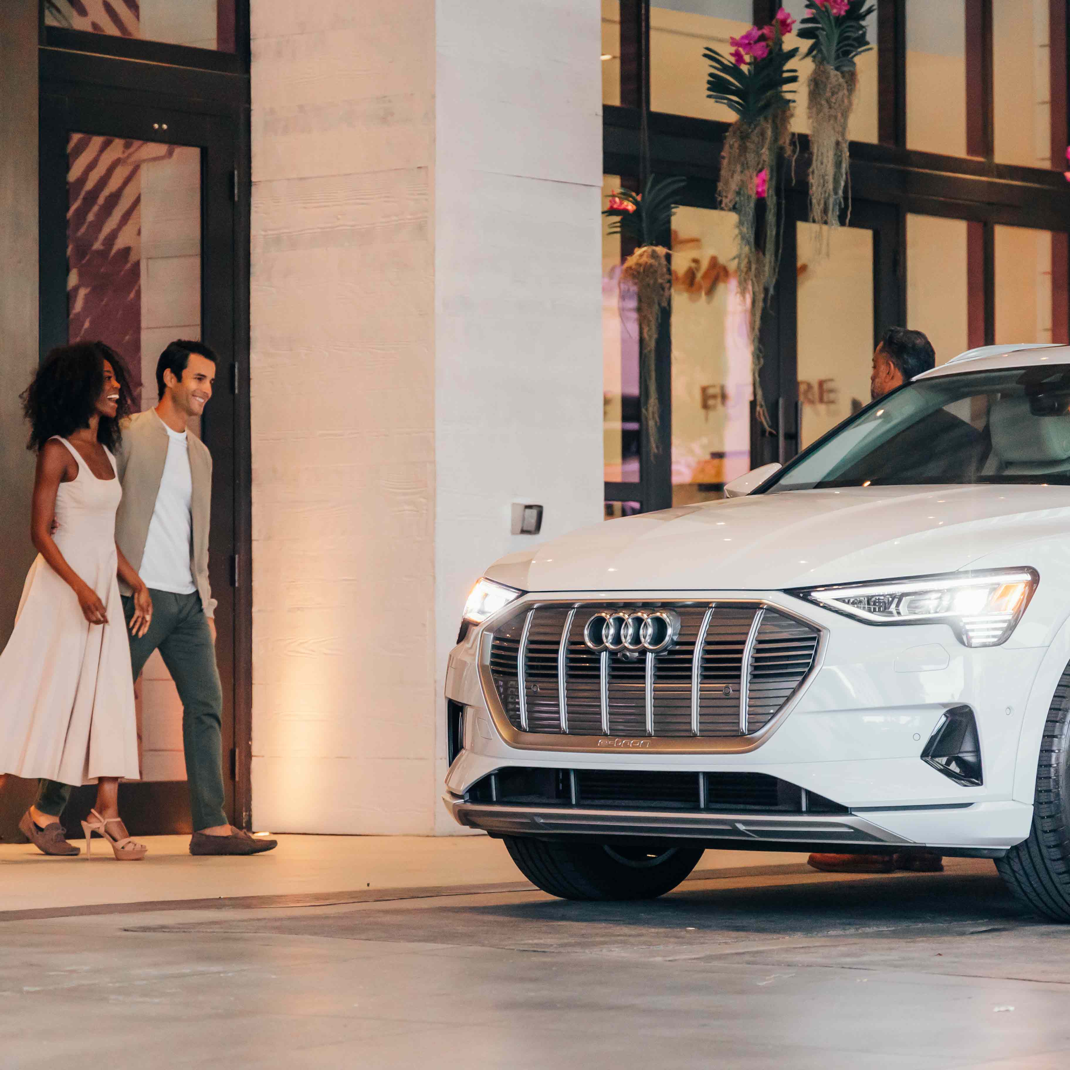 A well-dressed couple approaching their driver from the 1 Hotels and Audi partnership. 