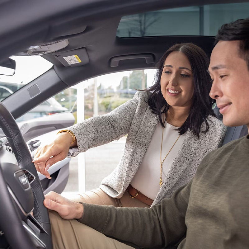 image of a Sales Consultant explaining features from the passenger seat to a prospective client in an audi