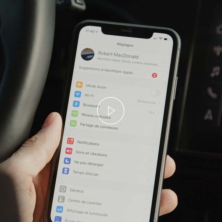 Gros plan d'une personne réglant le paramètre Apple Carplay sur son smartphone.
