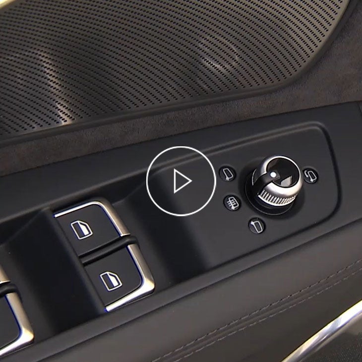 Close-up on the curb view mirror controls inside an Audi vehicle. 