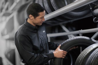 Service technician servicing tire.