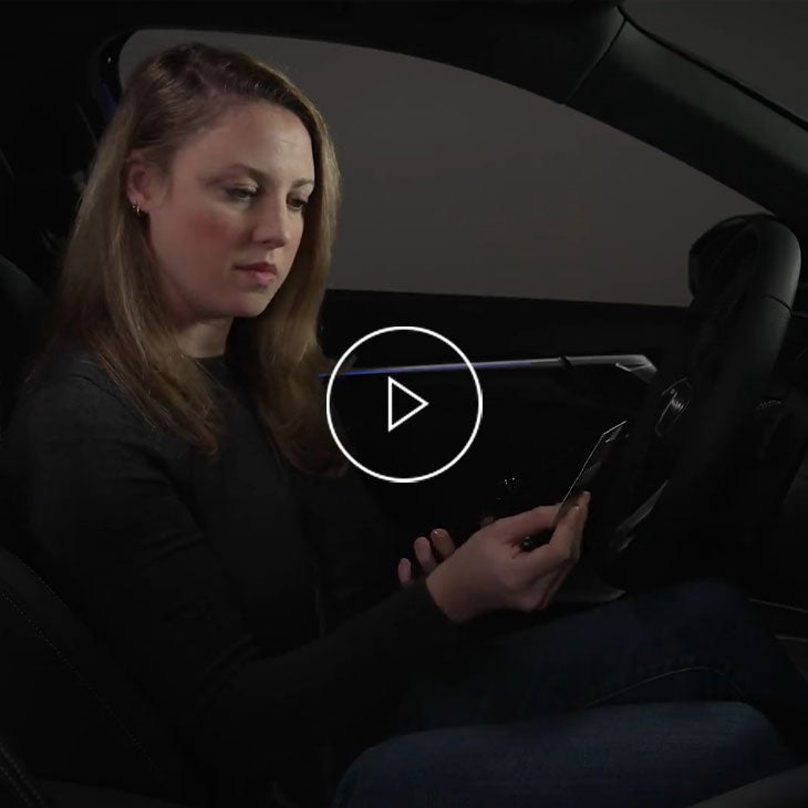  Close-up of a woman on a mobile phone sitting in her Audi vehicle. 