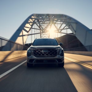 Front profile of the Audi SQ7 accelerating on a city bridge.
