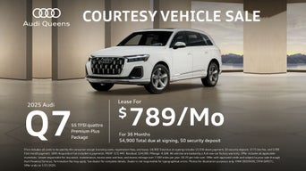 Front left view of a white Audi Q7 parked.