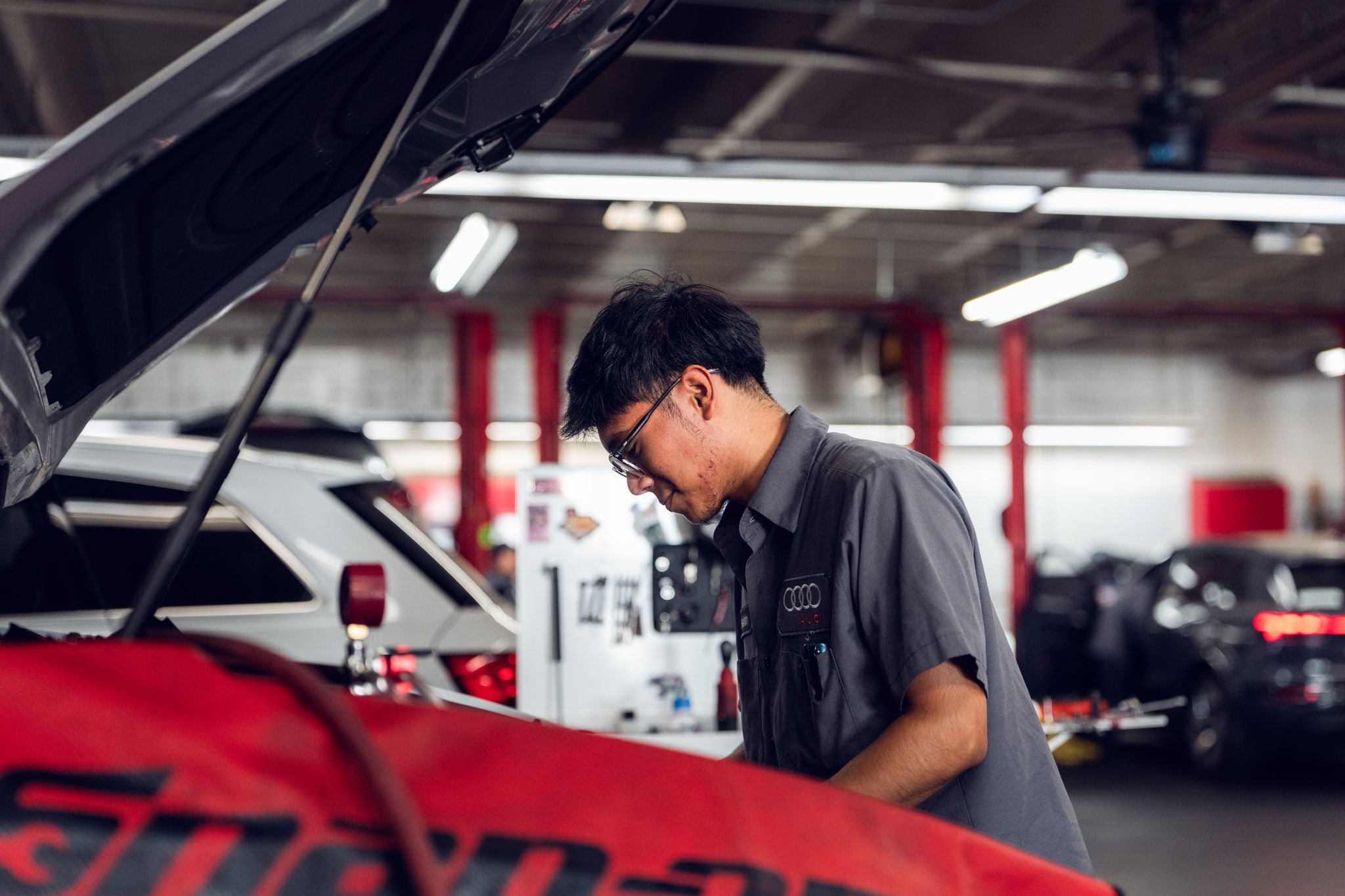 Audi service technician servicing a vehicle.