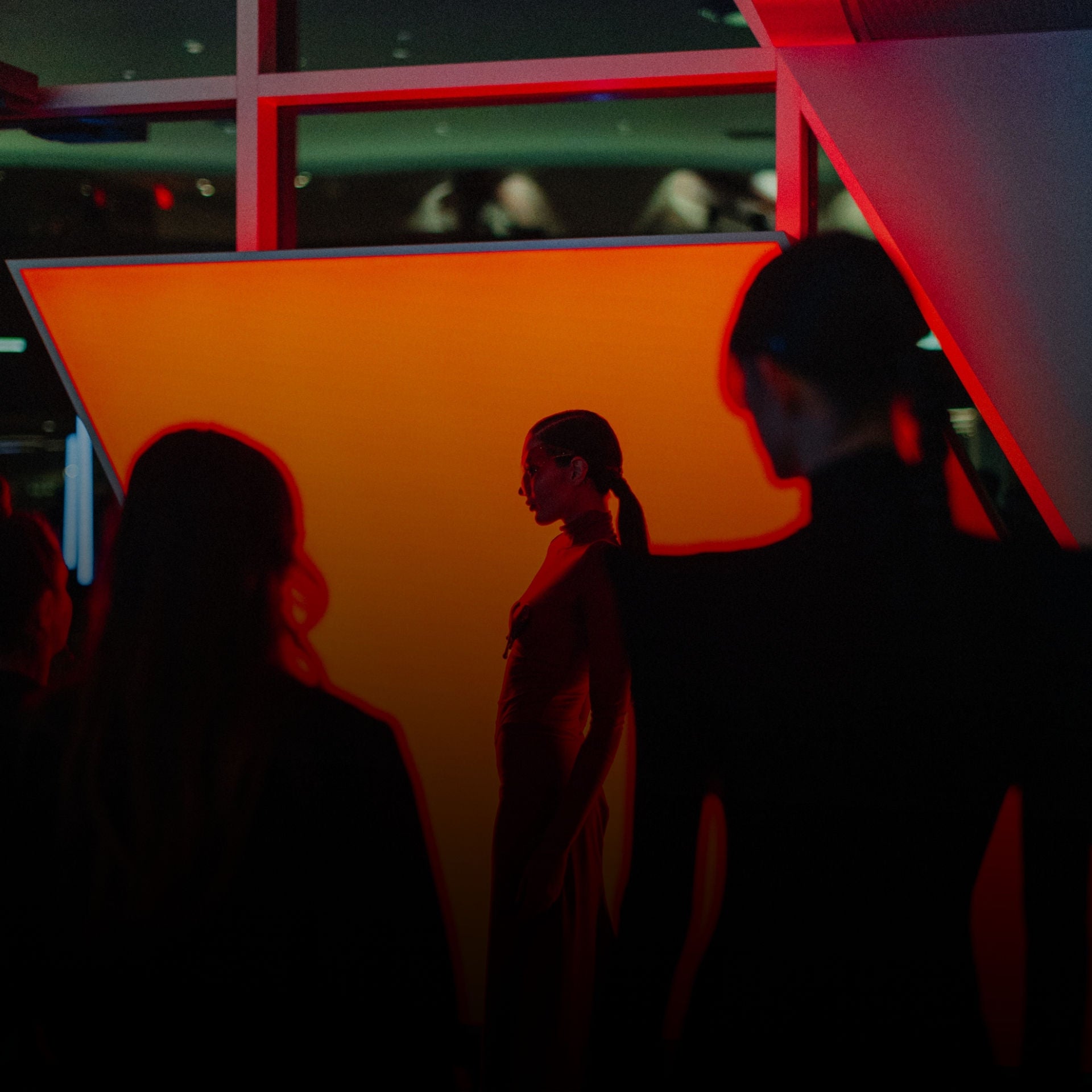 Two women sitting in the front seats of a parked Audi, viewed from outside the car. 