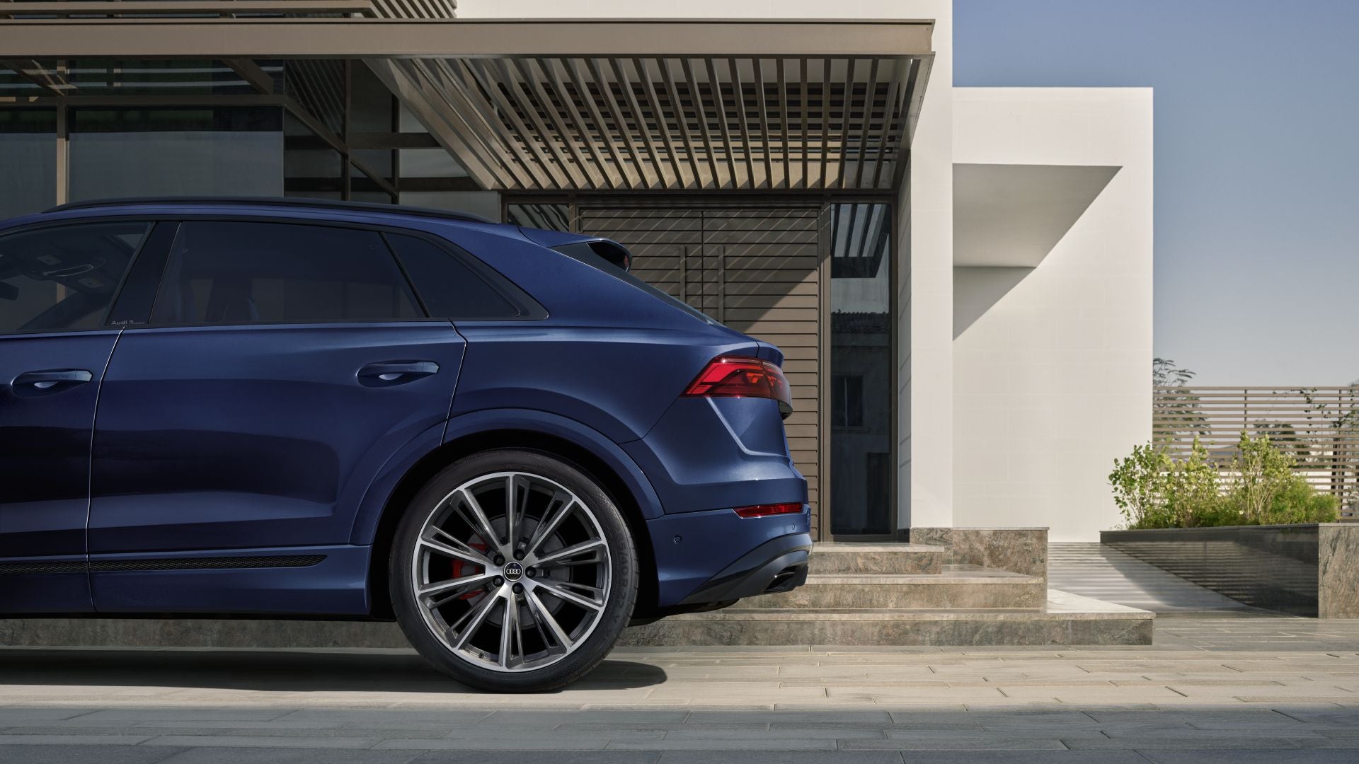 Rear profile view of an Audi Q8 parked.