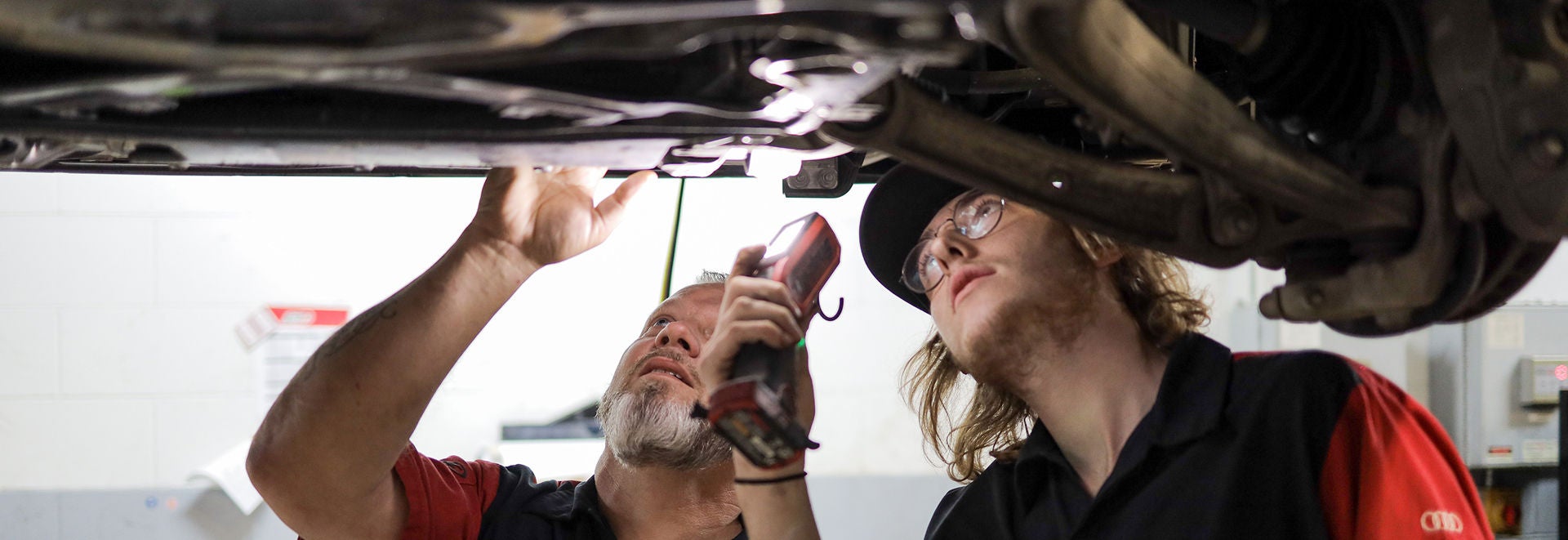 Service technician servicing a tire with another technician.