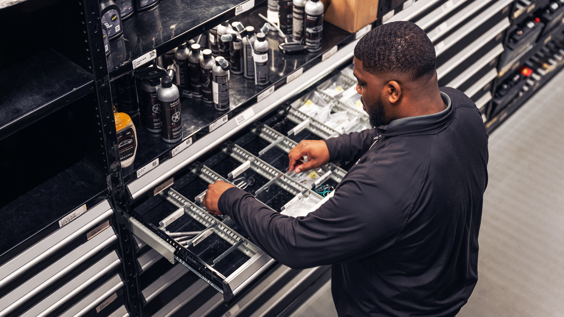 Service employee grabbing an Audi part