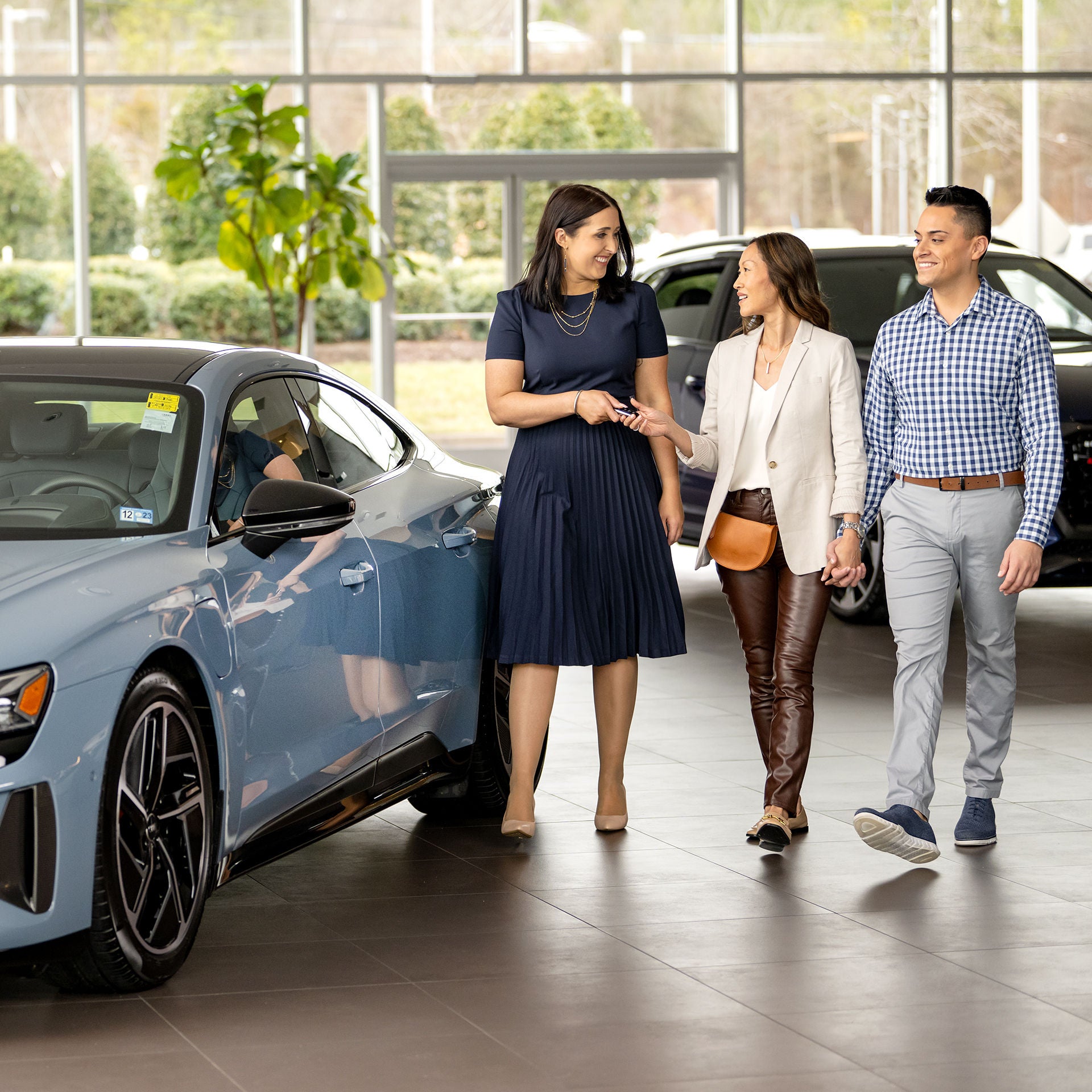 A mid-shot photo of two men talking in an Audi dealership.