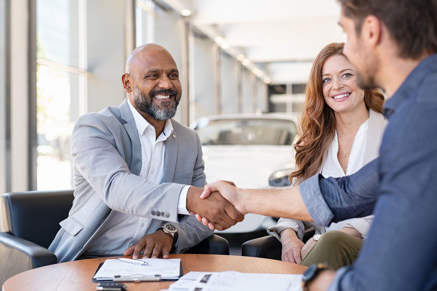 Couple buying a new car at dealership 