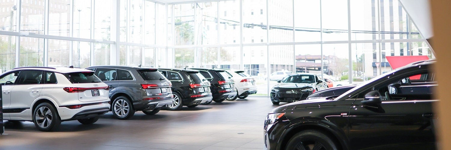 Audi cars lined up at a dealership showroom