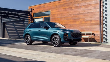 Front profile of the Audi Q8, showing the lit up LED headlights.
